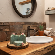 Bathroom counter with soap bars on a wooden stand, sink, and mirror.