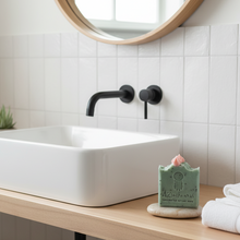 Bathroom sink with wooden countertop, black faucet, and decorative elements.