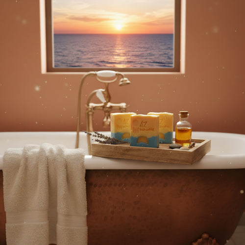 three bars of soap in a wooden crate against a cast iron tub with a towel and a windowed sunset
