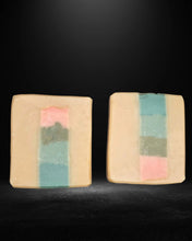 Two square soaps with colorful stripes on a black background