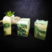 four bars of green and white soap topped with leaves made from soap dough